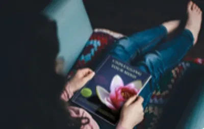 Woman reading Unplugging Your Mind guided meditation book
